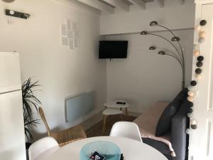 a living room with a table and a tv at Maison au milieu des bois et des animaux in Jouy-le-Potier