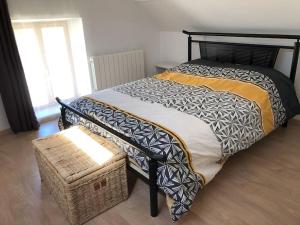 1 dormitorio con cama, cesta y ventana en Maison au milieu des bois et des animaux, en Jouy-le-Potier