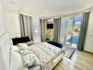 1 dormitorio con cama y ventana grande en Apartments Eman Resort, en Ulcinj