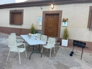 a white table and chairs sitting in front of a building at Casa Rural La Chicuela 
