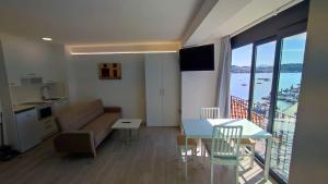 ein Wohnzimmer mit einem Sofa und einem Tisch in der Unterkunft Apartamentos Dabarca Combarro in Combarro