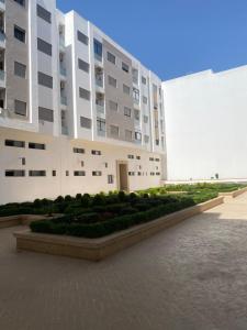 a large building with a garden in front of it at Appartement de charme in Kenitra