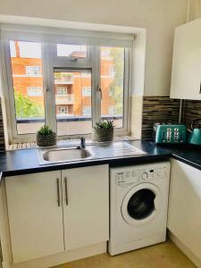a kitchen with a sink and a washing machine at City location- 2 bedroom apartment in London