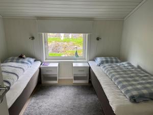 twee bedden in een kamer met een raam bij Sjarmerende gårdsbruk omgitt av vakker natur in Molde