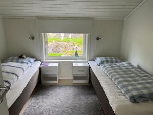 two beds in a room with a window at Sjarmerende og romslig bolig, omgitt av vakker natur in Molde
