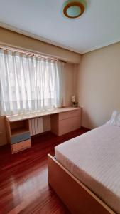 1 dormitorio con cama y ventana en Leiras Pulpeiro con Garaje, en Ourense