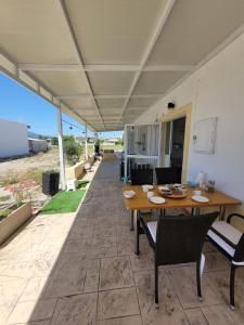 a table and chairs on a patio with a view of the ocean at Private 24sqm Studio in Lambi, Kos in Kos
