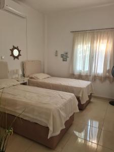 a bedroom with two beds and a clock on the wall at Private 24sqm Studio in Lambi, Kos in Kos