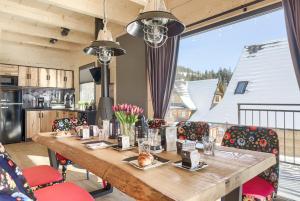 a dining room with a wooden table and chairs at Osada Czerwone Wierchy in Kościelisko