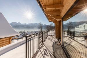 a balcony with a view of the snow covered mountains at Osada Czerwone Wierchy in Kościelisko