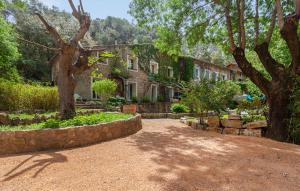 una grande casa in pietra con un albero di fronte di Les chambres de l'Issole- Le Mas de Maupasset a Cabasse