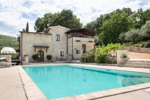 a villa with a swimming pool in front of a building at Volver B&B Spoleto in Spoleto