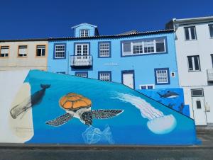 a mural on a wall in front of a building at SEASTAR nº38 in Horta