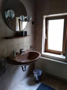 a bathroom with a sink and a mirror and a window at Kleines Häuschen am RheinSteig in Kaub
