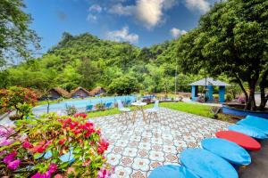 a resort with a pool with chairs and a table at Catba Papillon Garden Bungalows & Resort in Cat Ba