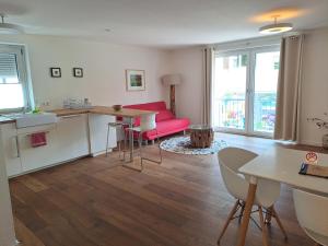 Il comprend une cuisine et un salon avec un canapé rouge. dans l'établissement City Center Apartments, à Kirchheim unter Teck