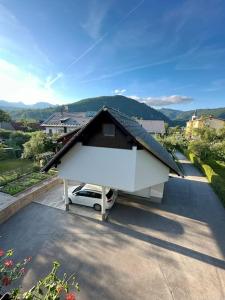 una casa con un'auto parcheggiata in un vialetto di Apartment Pirnat a Bohinj