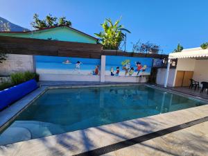 a swimming pool in front of a house with a painting on the wall at VILLA GRONDIN in Cilaos