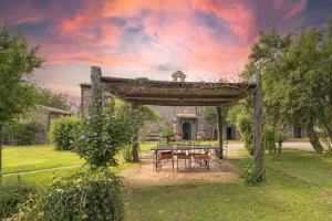 pergolato in legno con tavolo da picnic in cortile di Agriturismo Buriano a Lubriano