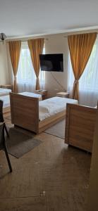 a bedroom with two beds and a flat screen tv at Tulipan Hotel Aquapark in Vyshkove