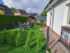 a small backyard with a table and chairs on the grass at Ein Stück Glück in Prerow