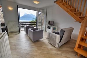 a living room with chairs and a stair case at Villa Betty in San Siro