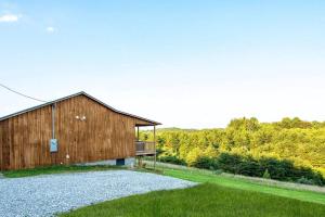 a wooden barn with a balcony on the side at Cedar Hill Heart of Hocking Hills in Rockbridge