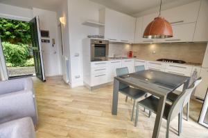 a kitchen with white cabinets and a table and chairs at Villa Betty in San Siro