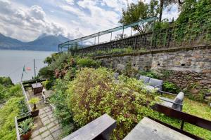 a stone retaining wall with benches next to the water at Villa Betty in San Siro