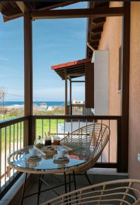 a table on a balcony with a view of the ocean at Melia Villas in Ierissos