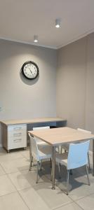 a dining room with a table and chairs and a clock at Menlyn Maine Trilogy Apartment 808 in Pretoria