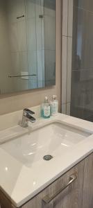 a bathroom sink with a mirror and two bottles of soap at Menlyn Maine Trilogy Apartment 808 in Pretoria