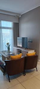 a living room with couches and a flat screen tv at Menlyn Maine Trilogy Apartment 808 in Pretoria