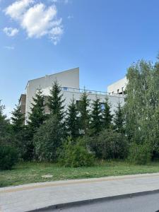 a building on the side of a road with trees at Luxury Penthouse with Large Terrace & Panoramic Old Town View in Vilnius