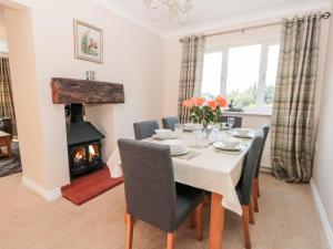 a dining room with a table and a fireplace at Church View in Hull