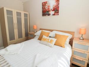 a bedroom with a white bed with orange pillows at Church View in Hull