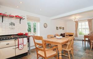 Ebrington的住宿－Kissing Gate Cottage，厨房配有木桌和炉灶。