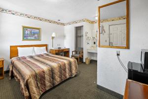 a hotel room with a bed and a television at Friendship Inn Hotel in Killeen