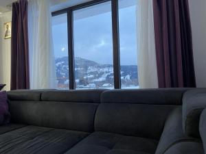 a living room with a couch and a large window at Casa EVA in Panaci