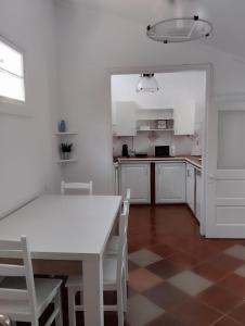 uma cozinha com uma mesa branca e cadeiras brancas em SEASTAR nº36 em Horta