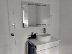 uma casa de banho branca com um lavatório e um espelho em SEASTAR nº36 em Horta