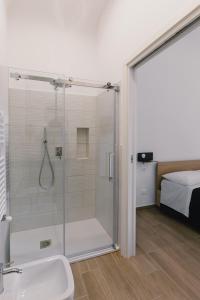 Un baño con ducha y lavabo y una cama. en Ballaro' House, en Palermo