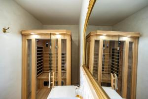 uno spogliatoio con specchio e alcune rastrelliere per il vino di L'Oliveraie d'Eurocentre - Toulouse Nord a Castelnau-dʼEstrétefonds