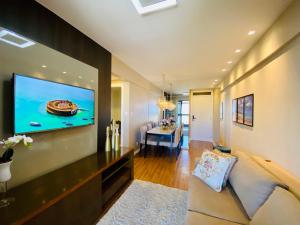 a living room with a flat screen tv on a wall at Maravilhoso! 2 suítes! Sua casa, no Salvador Prime! Wi-fi de 500 Mbps! in Salvador