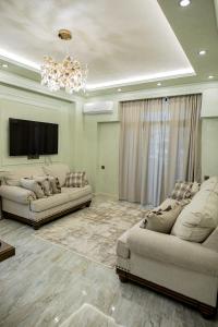 uma sala de estar com dois sofás e uma televisão em Comfy Home em Yerevan