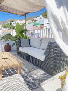 a patio with a couch and a wooden table at Los Nidos Apartments, Frigiliana in Frigiliana