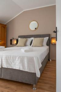 1 dormitorio con 1 cama blanca grande y espejo en House Madrino, en Kreševo