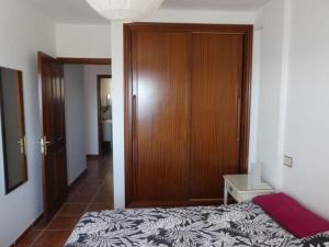 een slaapkamer met een bed en een houten deur bij Seaview Cabezo flat fully equipped with parking in El Médano