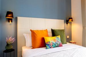 una camera da letto con un letto con cuscini colorati di Magnini Rooms a Cagliari