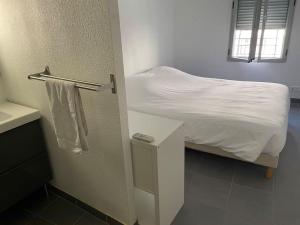 a bedroom with a bed with white sheets and a window at T2 N1 Hyper-centre climatisé parking in Albi